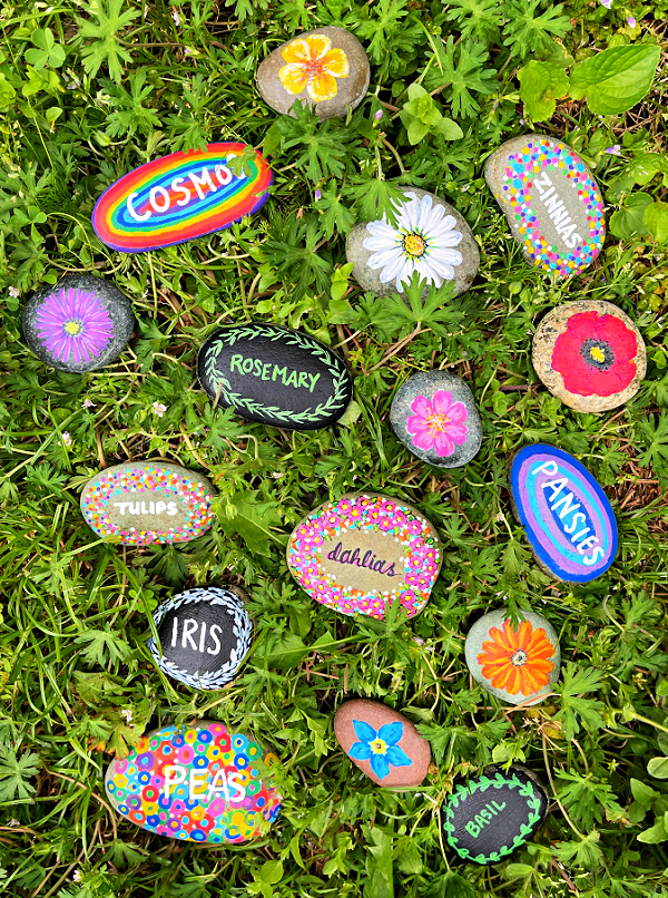 Painted rock plant markers in grass
